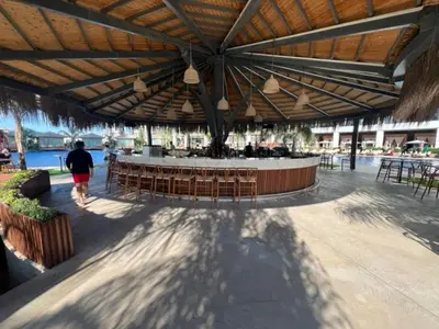 a person walking under a pavilion with a table and chairs at Grand Sapphire,Luxury Residence BY Report Homes Northern Cyprus in Ayia Napa