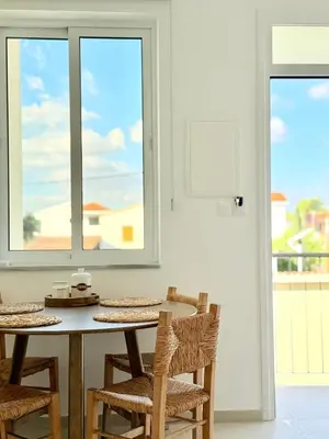 a dining room with a table and chairs and windows at Kiti Traditional Residences in Larnaka