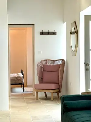 a living room with a chair and a mirror at Kiti Traditional Residences in Larnaka