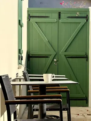 a green door with a coffee cup on a table at Kiti Traditional Residences in Larnaka