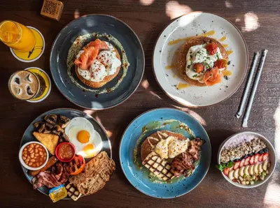 four plates of breakfast food on a wooden table at Kiti Traditional Residences in Larnaka