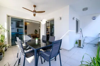 a dining room with a black table and chairs at Parkside 2 Bedroom Apartment in Larnaka