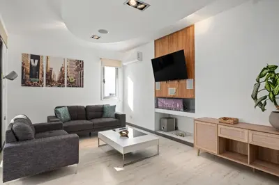 a living room with a couch and a tv at Parkside 2 Bedroom Apartment in Larnaka