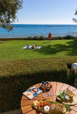 a table with food on it with the ocean in the background at Melon Boutique Seafront Apartment in Limassol