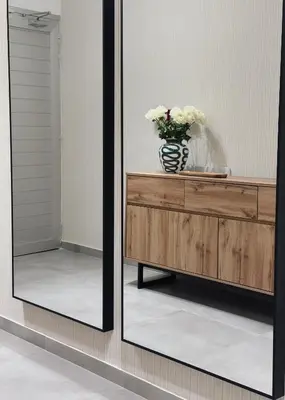 a mirror on a dresser with a vase of flowers at Grace Living in Limassol