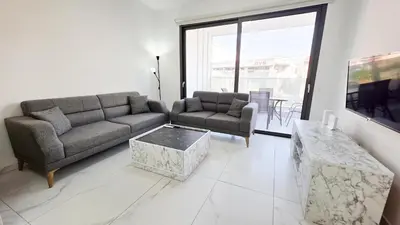 a living room with a couch and a table at Pool Citylux Apartment in Larnaka
