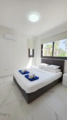 a bedroom with a large bed with towels on it at Pool Citylux Apartment in Larnaka