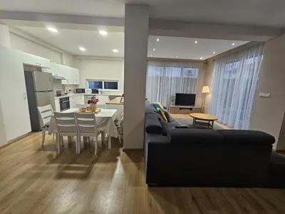 a living room with a couch and a table and a kitchen at 3 bedroom villa in Voroklini