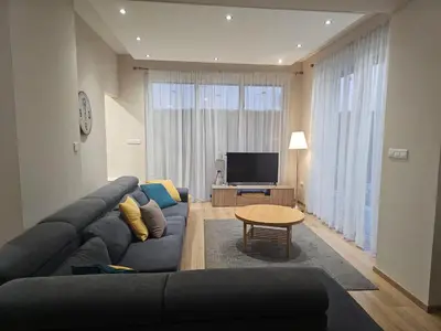 a living room with a blue couch and a television at 3 bedroom villa in Voroklini