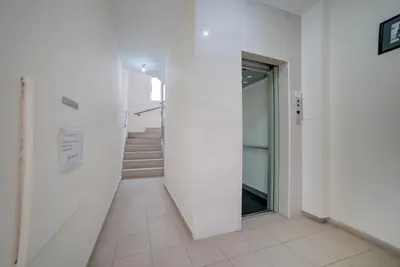 a hallway with white walls and stairs in a building at Cozy Mackenzie Getaway in Larnaka