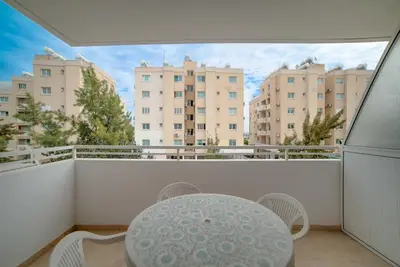 a balcony with a table and chairs and buildings at Cozy Mackenzie Getaway in Larnaka