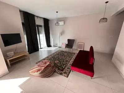 a living room with a table and a red chair at Villa - Sleeps 6 - Near Local Attractions in Limassol