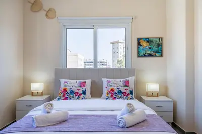 a bedroom with a large bed with pillows and a window at Ondo 2-Bedroom Apartment in Larnaka