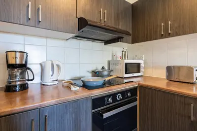 a kitchen with a counter top with a stove and a microwave at Ondo 2-Bedroom Apartment in Larnaka