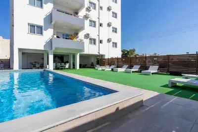 a hotel with a swimming pool and a building at Ondo 2-Bedroom Apartment in Larnaka