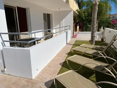 a group of chairs on a balcony with a palm tree at Nissi Bliss Apartment in Ayia Napa
