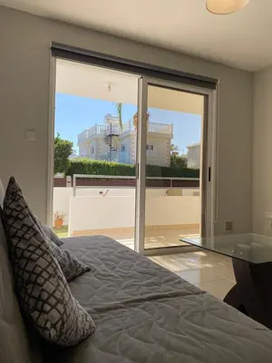a bedroom with a bed and a large glass window at Nissi Bliss Apartment in Ayia Napa