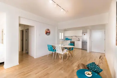 a living room and dining room with a table and chairs at Limanaki Beach Aparment in Larnaka
