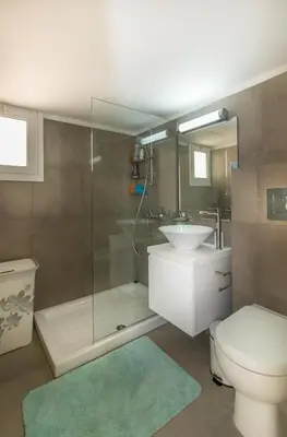 a bathroom with a shower and a toilet and a sink at Limanaki Beach Aparment in Larnaka