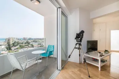 a camera and chairs in a room with a window at Limanaki Beach Aparment in Larnaka