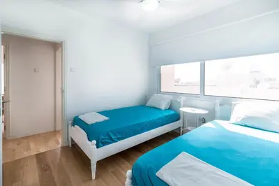 a bedroom with two beds and a window at Limanaki Beach Aparment in Larnaka