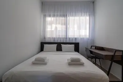 a bedroom with a large white bed and a desk at Pearl Beach Luxury Family Suite in Limassol