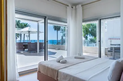 a bedroom with a bed and a view of the ocean at Beachfront Luxury Living Limassol in Limassol