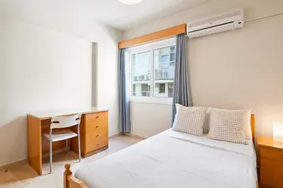 a bedroom with a bed and a desk and a window at Spacious City Centre Living in Nicosia
