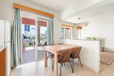 a kitchen and dining room with a wooden table and chairs at Spacious City Centre Living in Nicosia