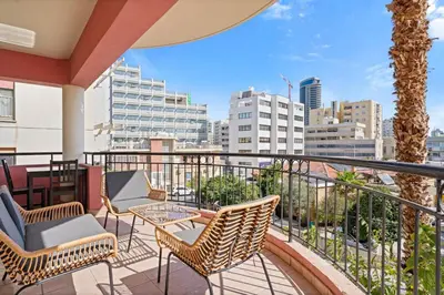 a balcony with chairs and tables and a city skyline at Spacious City Centre Living in Nicosia
