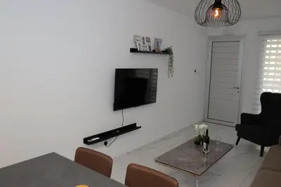 a living room with a tv on a white wall at ELIA Elegant Central Suite Larnaca in Larnaka