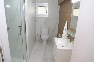 a bathroom with a toilet and a shower and a sink at ELIA Elegant Central Suite Larnaca in Larnaka