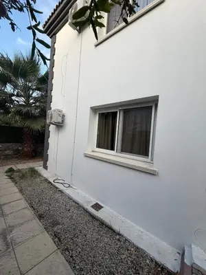a window on the side of a white house at Villa Keskin - Girne in Ayios Ioannis