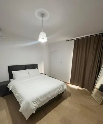 a bedroom with a white bed and a window at Villa Keskin - Girne in Ayios Ioannis
