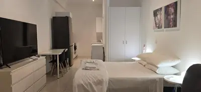 a white room with a bed and a flat screen tv at Habito Luxury Apartment - Breakbooking CY in Limassol