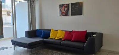 a couch with colorful pillows on it in a room at Executive 2BR Spacious Apartment , Limassol Center, 2 Balconies, Ideal Business Stay - SuperCentro! in Limassol