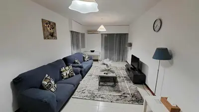 a living room with a blue couch and a tv at City center beach and supermarket walking distance in Limassol