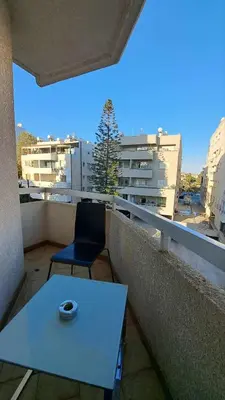a blue table and a chair on a balcony at City center beach and supermarket walking distance in Limassol