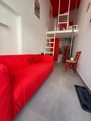 a red couch in a living room with a ladder at RED Cabin-Larnaca Centrum in Larnaka