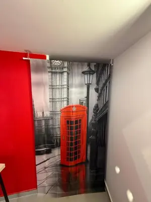 a red phone booth in a room with a wall at RED Cabin-Larnaca Centrum in Larnaka