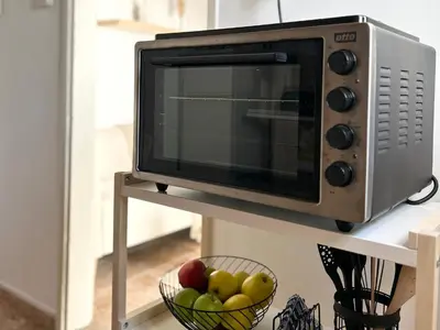 a microwave on a shelf with a bowl of apples at Charming 1-BR Stay Near City Centre, Marina and Beaches - Perfect for Couples, Business or Solo Travellers in Limassol