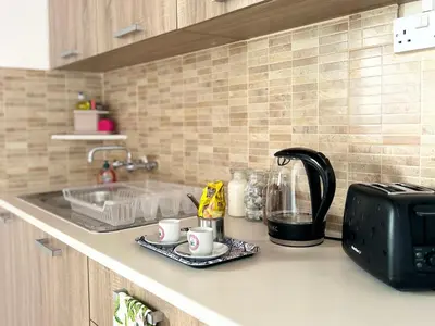 a kitchen counter with a toaster and coffee cups at Charming 1-BR Stay Near City Centre, Marina and Beaches - Perfect for Couples, Business or Solo Travellers in Limassol