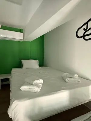 a green and white bed with two towels on it at GREEN Cabin-Larnaca Centrum in Larnaka
