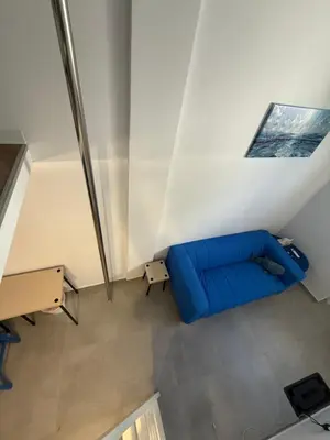 a living room with a blue couch and a table at BLUE Cabin-Larnaca Centrum in Larnaka