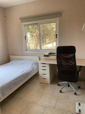 a bedroom with a desk and a bed and a chair at Holiday House in Oroklini in Voroklini