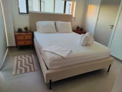 a bedroom with a bed with white sheets and pillows at Ruach Villa in Paralimni