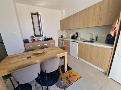 a kitchen with a wooden table and some chairs at Ruach Villa in Paralimni