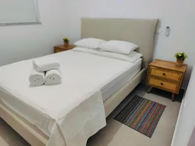 a bedroom with a white bed with towels on it at Ruach Villa in Paralimni