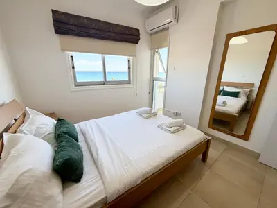 a bedroom with a bed and a large mirror at Golden Nest by the Sea in Larnaka
