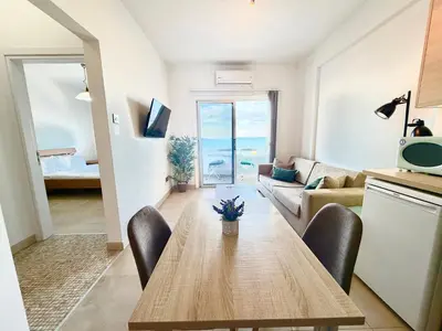 a kitchen and living room with a table and a couch at Golden Nest by the Sea in Larnaka